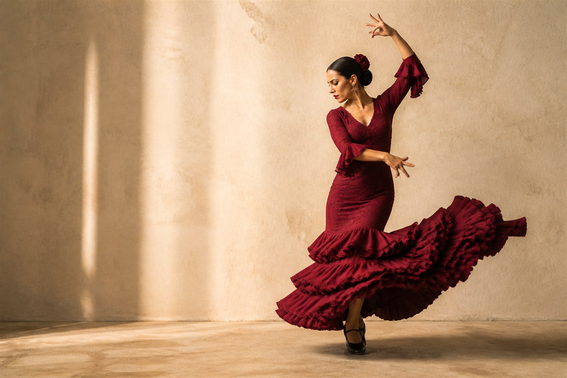 Bailaora de flamenco con vestido burdeos interpretando una coreografía